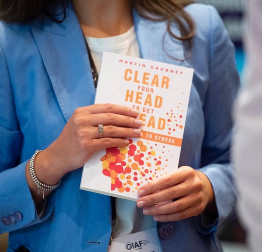 Woman in blue jacket holding "Clear your head to get ahead" book
